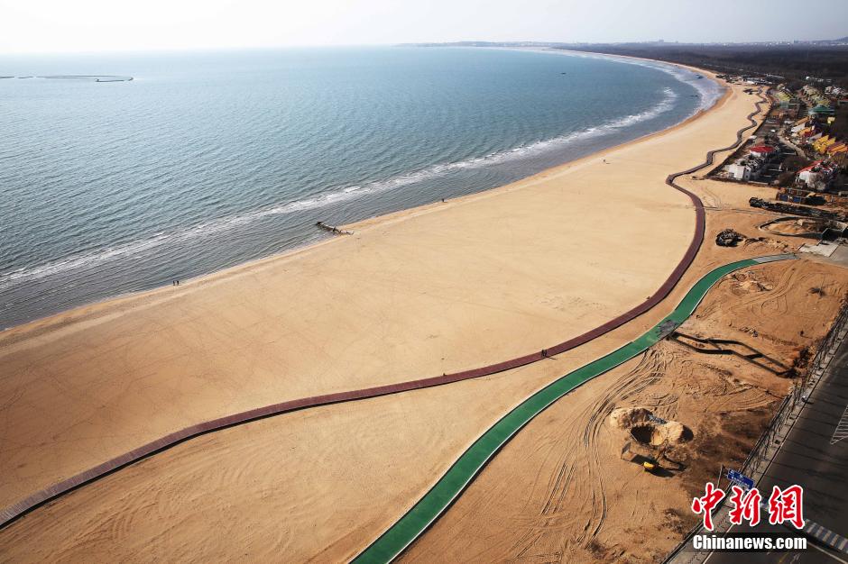 3月13日，秦皇島萬(wàn)米臨海沙灘木棧道。據了解，該木棧道全長(cháng)約4200米，與北戴河區原有的7500米木棧道對接后全線(xiàn)總長(cháng)度1.17萬(wàn)米，整個(gè)木棧道東起秦皇島體育基地游船碼頭，西至北戴河濕地公園，呈波浪形蜿蜒10.4公里海岸線(xiàn)。 中新社發(fā) 曹建雄 攝 CNSPHOTO