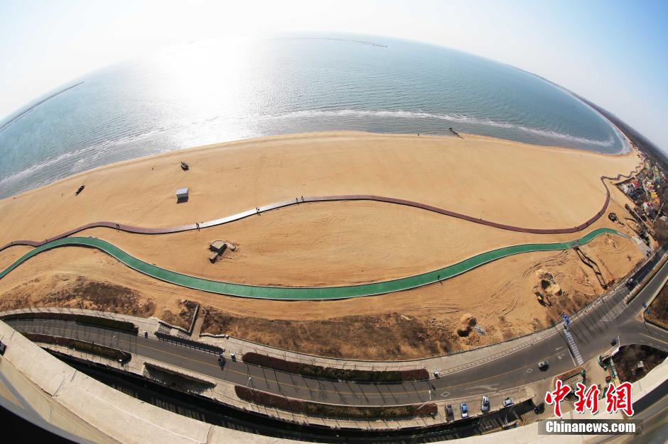 3月13日，秦皇島萬(wàn)米臨海沙灘木棧道。據了解，該木棧道全長(cháng)約4200米，與北戴河區原有的7500米木棧道對接后全線(xiàn)總長(cháng)度1.17萬(wàn)米，整個(gè)木棧道東起秦皇島體育基地游船碼頭，西至北戴河濕地公園，呈波浪形蜿蜒10.4公里海岸線(xiàn)。 中新社發(fā) 曹建雄 攝 CNSPHOTO